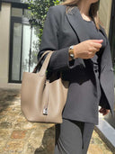 Piana Bucket bag in beige vegan leather with gold hardware, worn with black blazer and pants