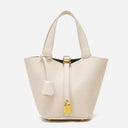 Elegant beige bucket bag in vegan leather with gold hardware and pebbled texture