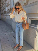Woman wearing casual outfit carrying brown Piana bucket bag with golden hardware on city street