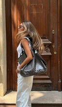 Woman carrying Élodie Tote Bag with signature pattern and detachable pouch in urban setting