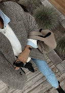 Piana bucket bag in beige vegan leather with gold accents, worn with casual chic outfit including herringbone coat and jeans